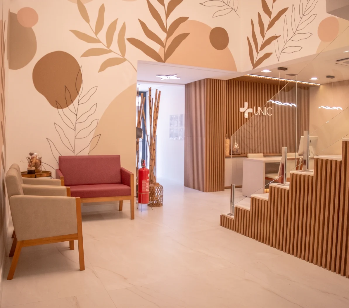 Recepção do Hospital Unic, com mural botânico, painel ripado de madeira e área de espera